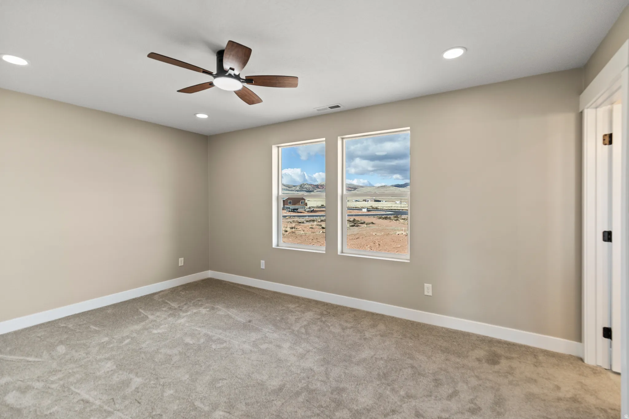 Carpeted empty room with ceiling fan and recessed lighting