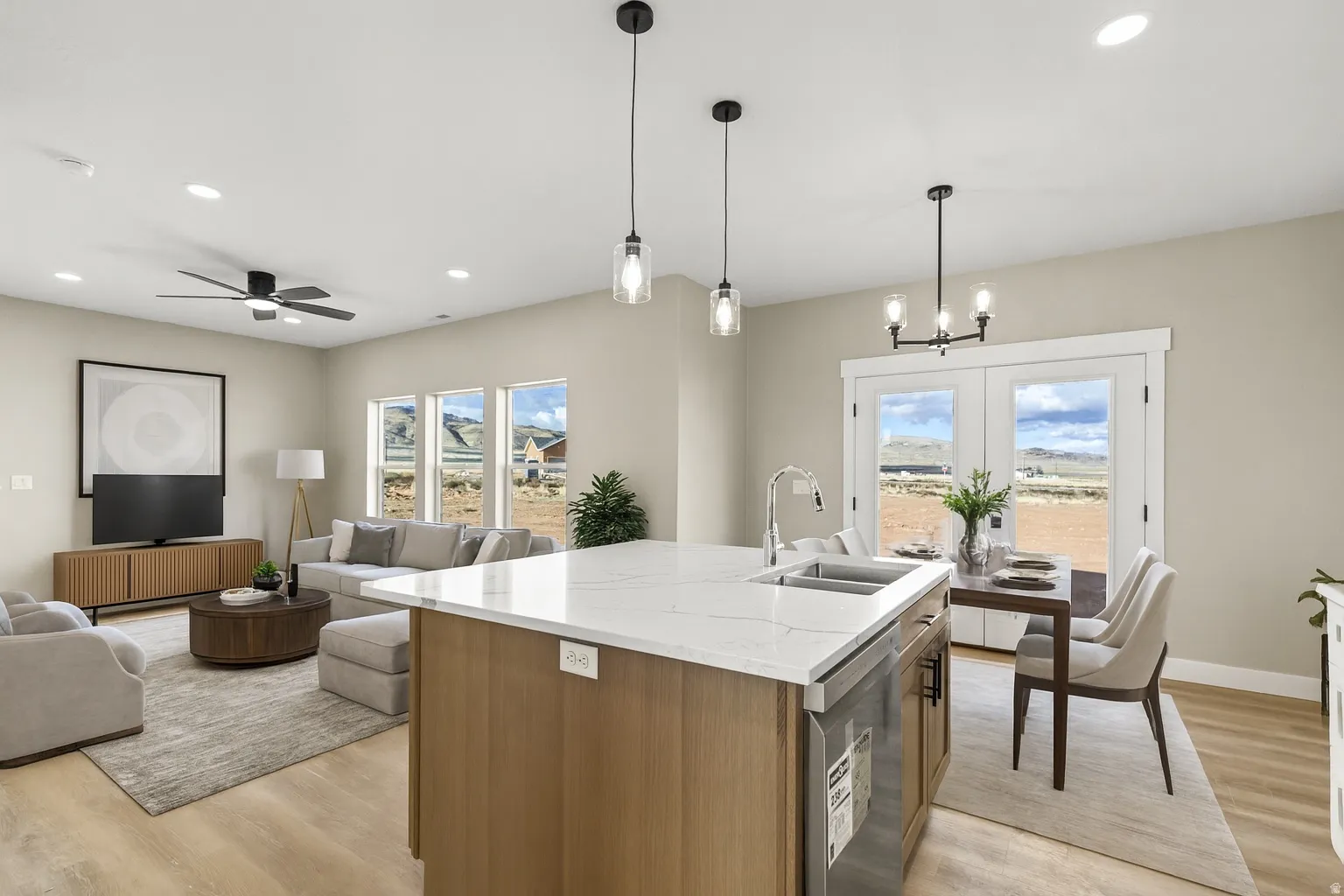 Kitchen with light stone counters, a center island with sink, light wood-style floors, open floor plan, and wood finish cabinetry