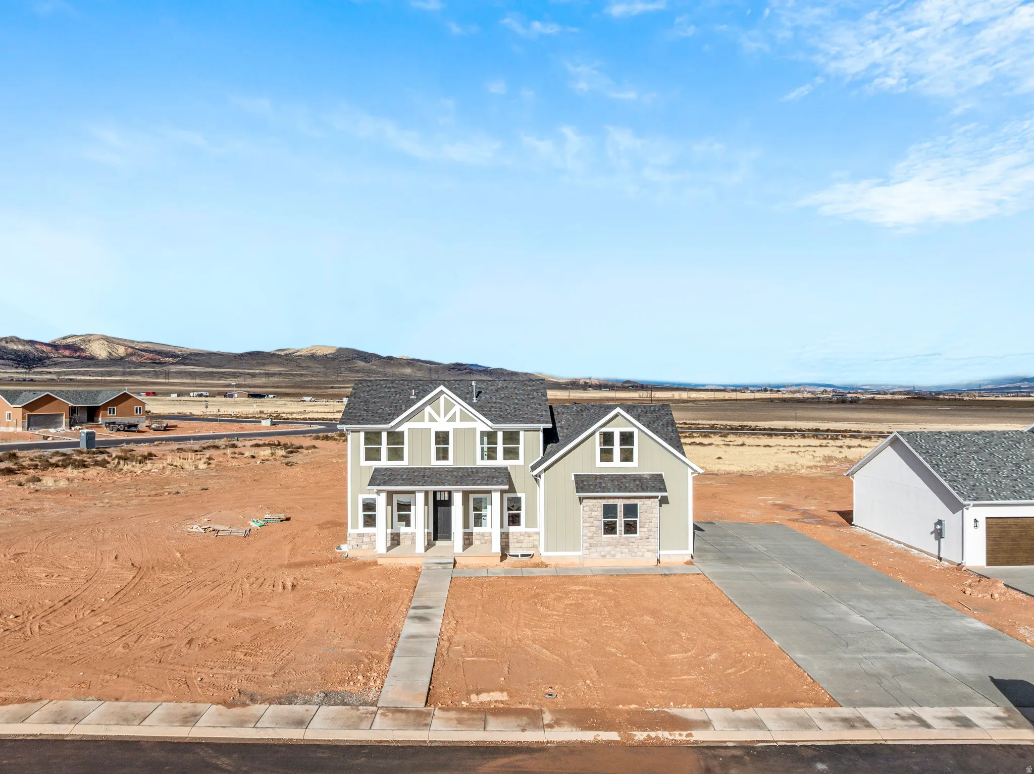 View of front facade with stone siding and concrete driveway