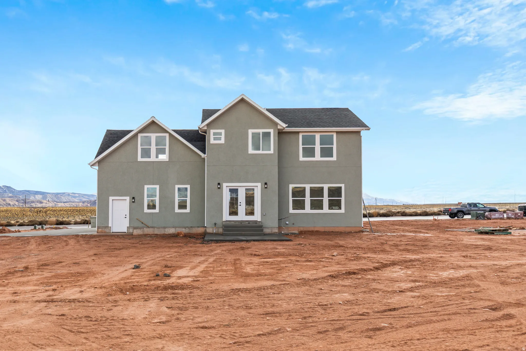 View of front of house featuring french doors, a mountain view, roof with shingles, and stucco siding