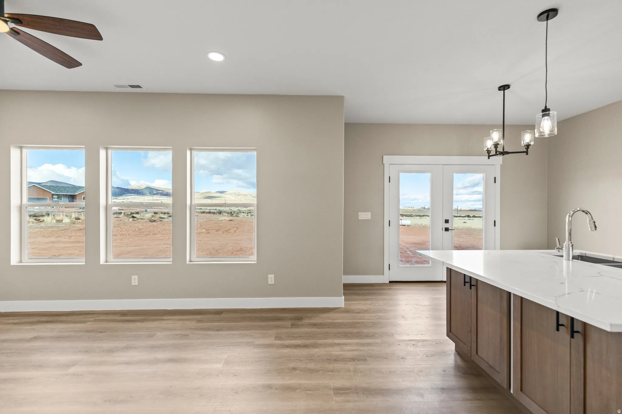 Kitchen featuring decorative light fixtures, french doors, light wood-style flooring, plenty of natural light, and recessed lighting
