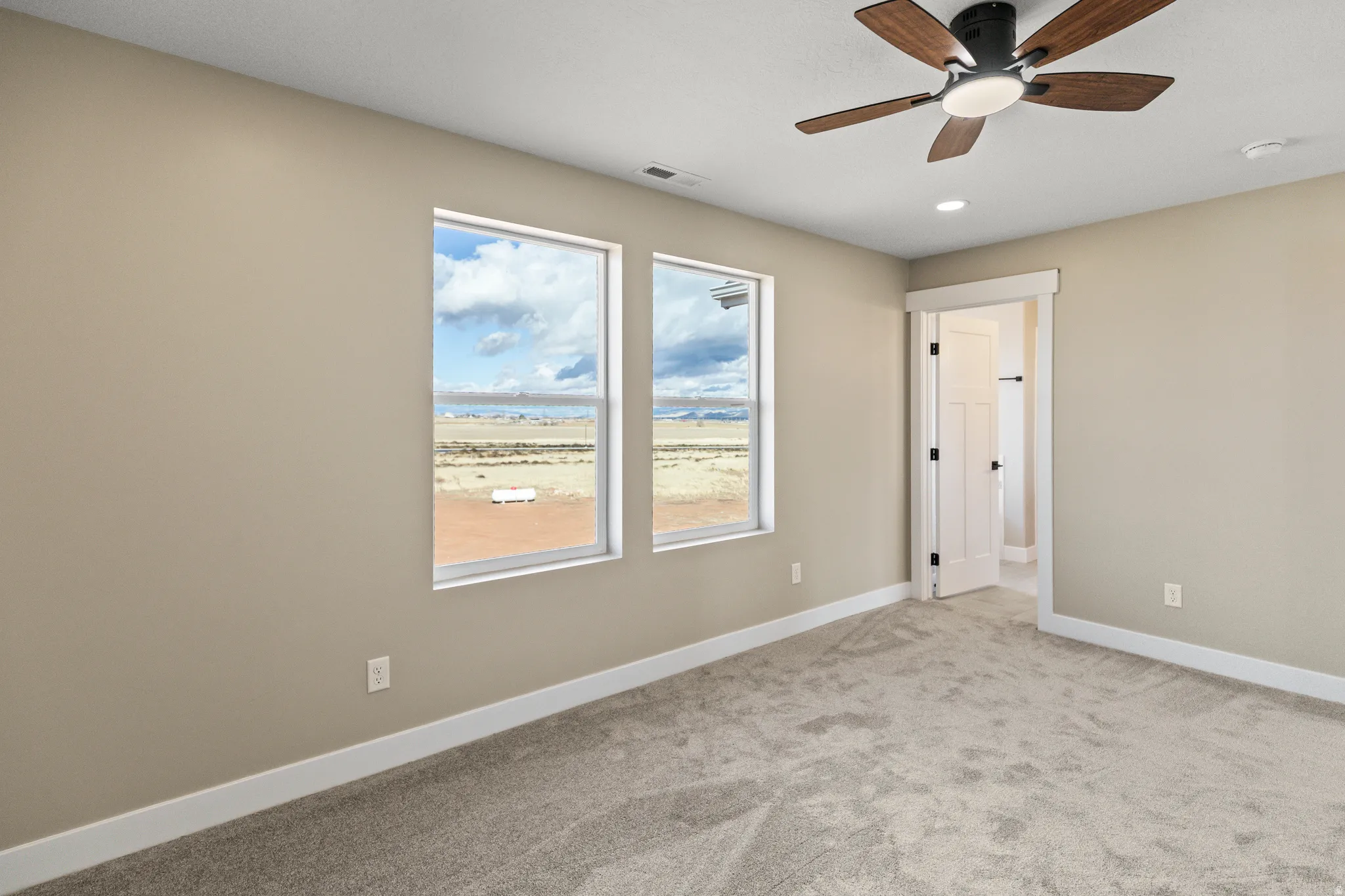 Unfurnished bedroom featuring carpet and a ceiling fan