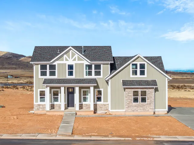 Craftsman-style house featuring covered porch, stone siding, board and batten siding, and roof with shingles