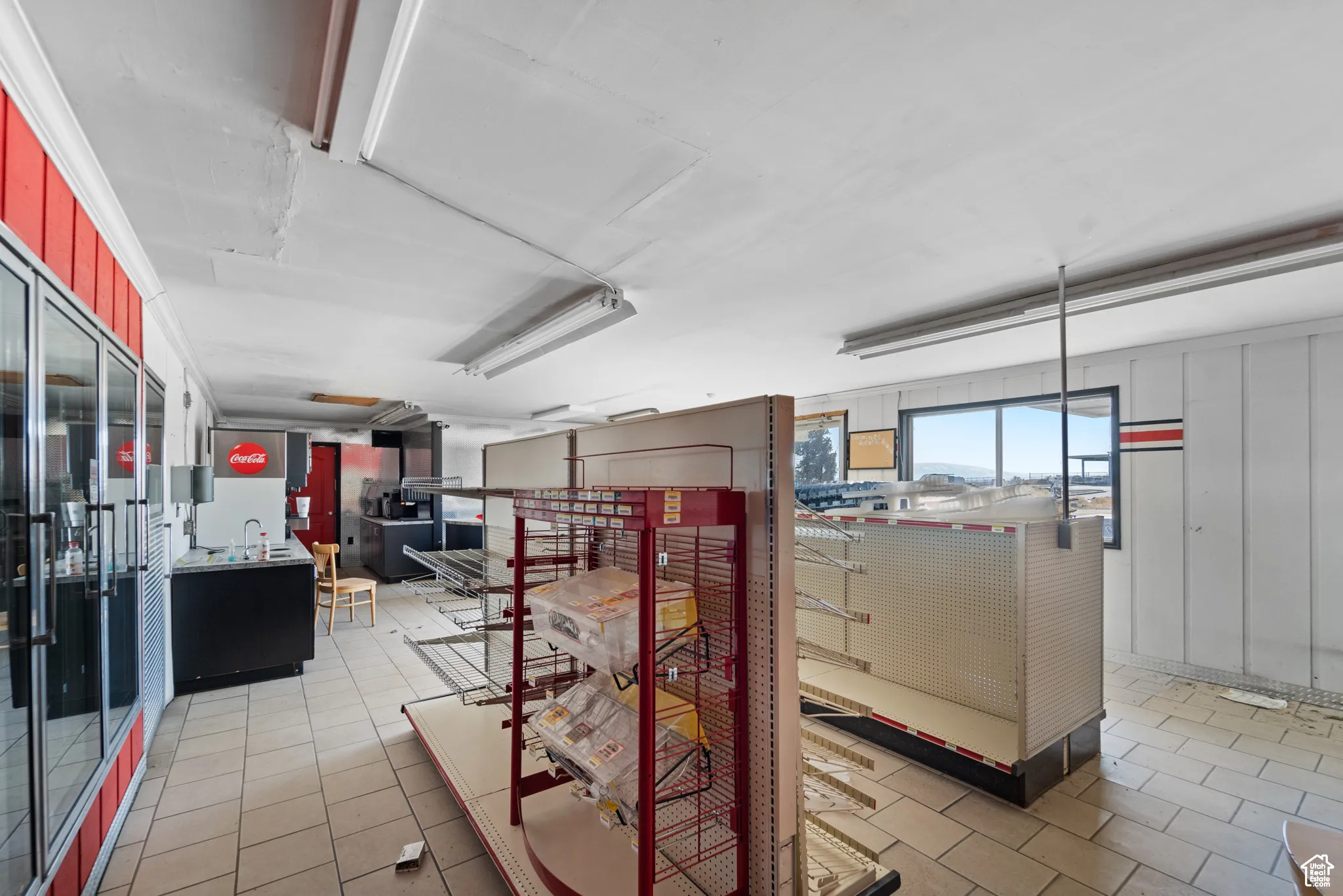 Hallway featuring light tile patterned floors and a sink