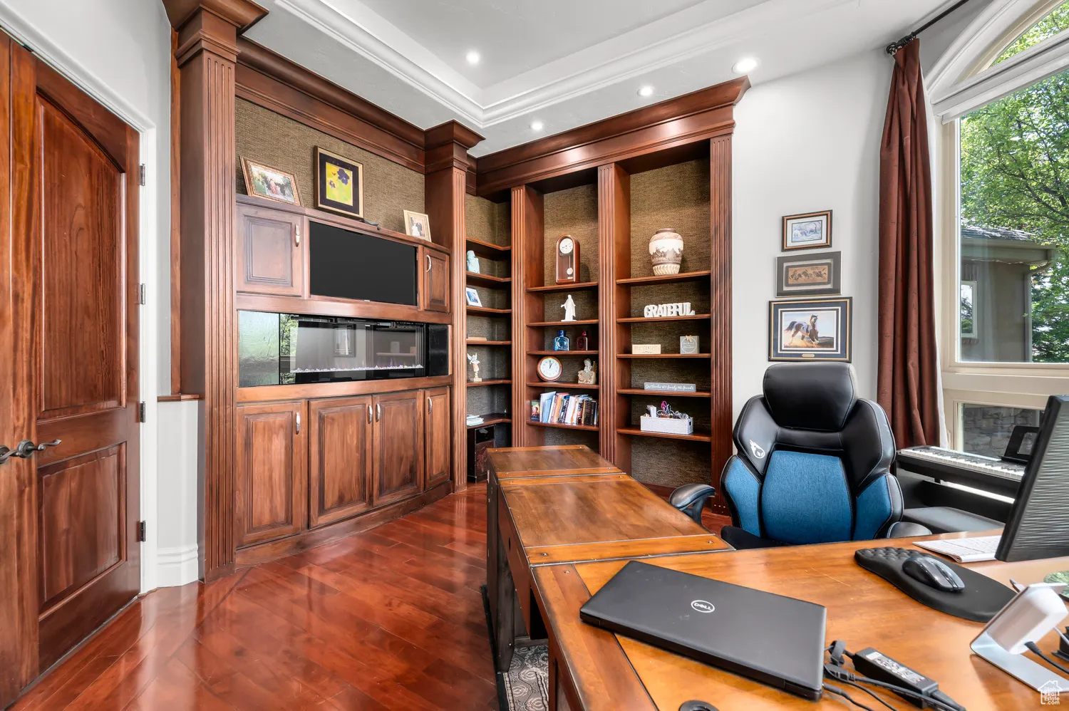 Home office featuring dark wood finished floors, built in features, ornamental molding, and recessed lighting