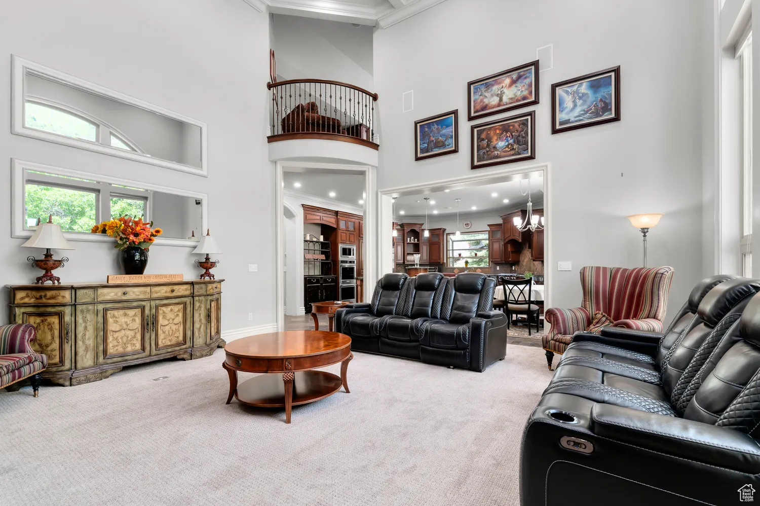 Carpeted living room with a towering ceiling, crown molding, healthy amount of natural light, and baseboards