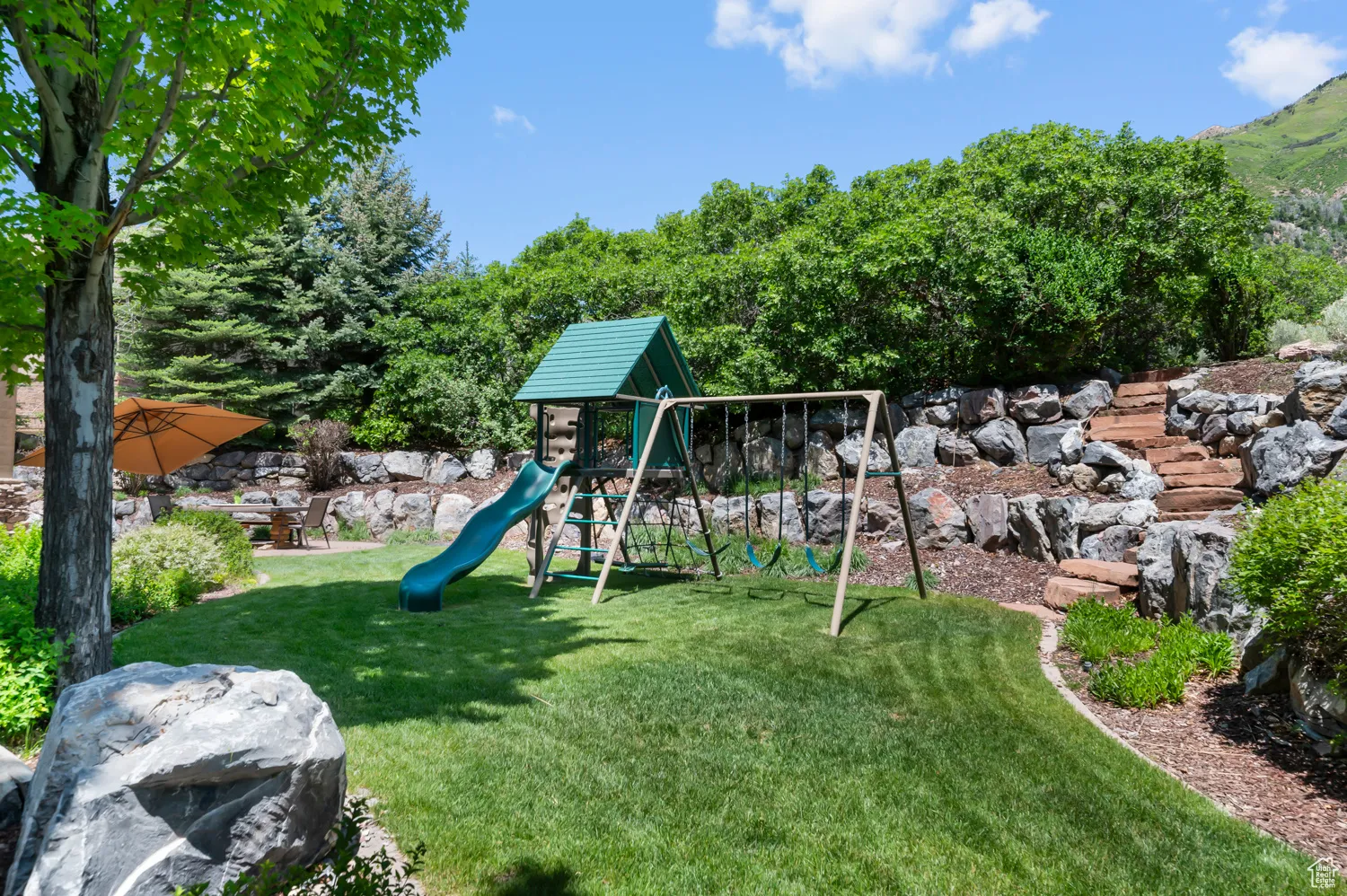 View of playground featuring a yard and a mountain view