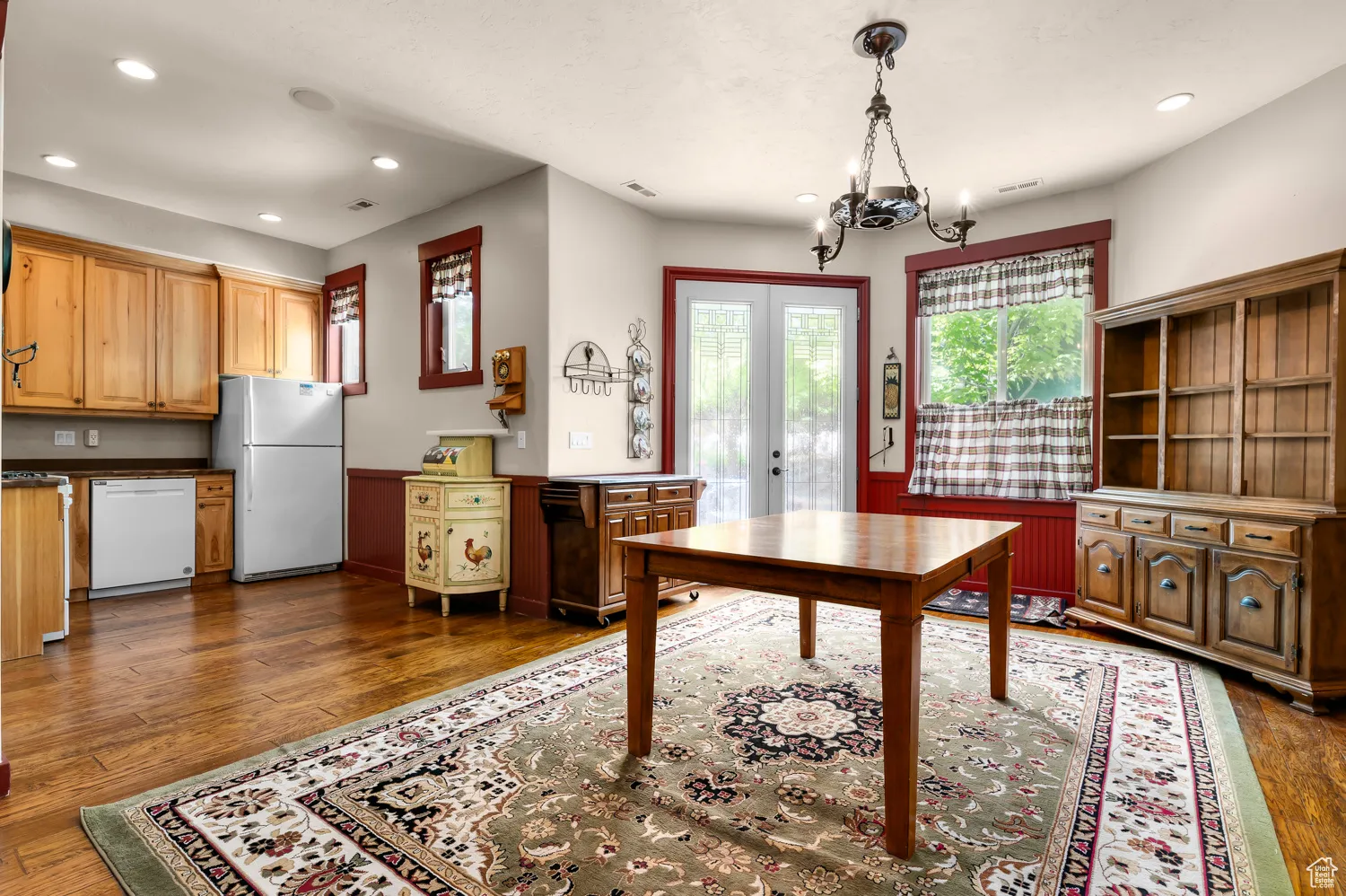 Office area with a chandelier, recessed lighting, dark wood finished floors, a wainscoted wall, and french doors