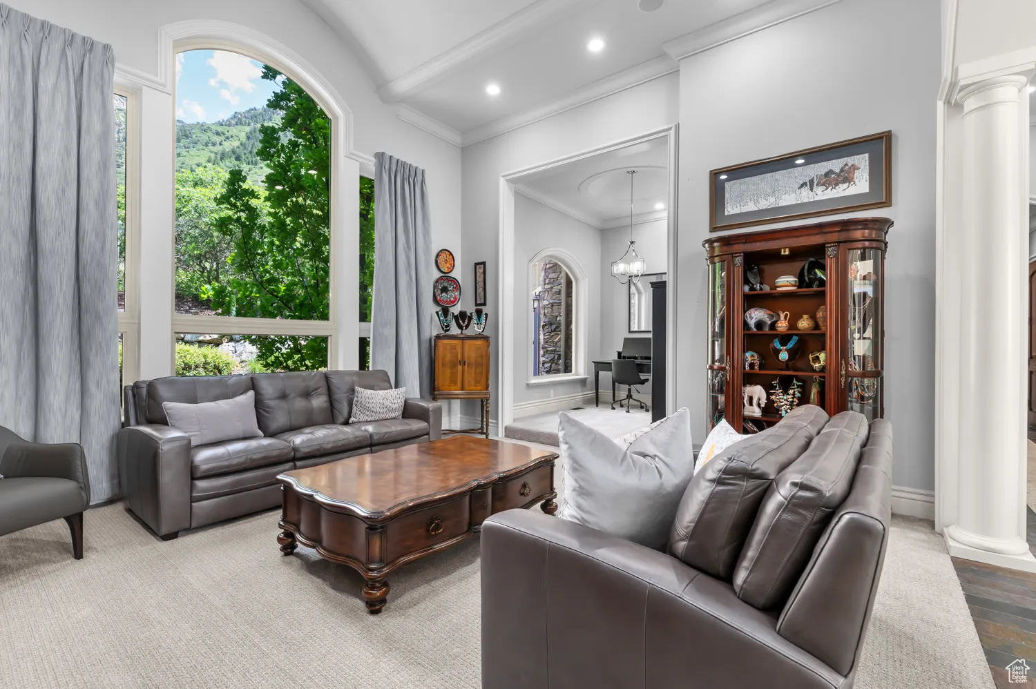 Living room with decorative columns, ornamental molding, recessed lighting, and lofted ceiling