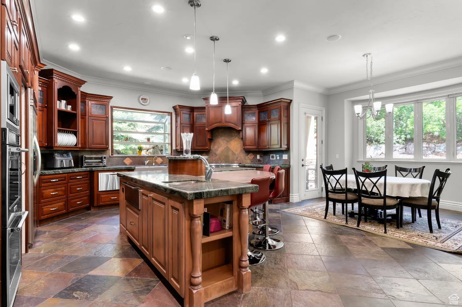 Kitchen with open shelves, stone tile flooring, crown molding, a sink, and recessed lighting