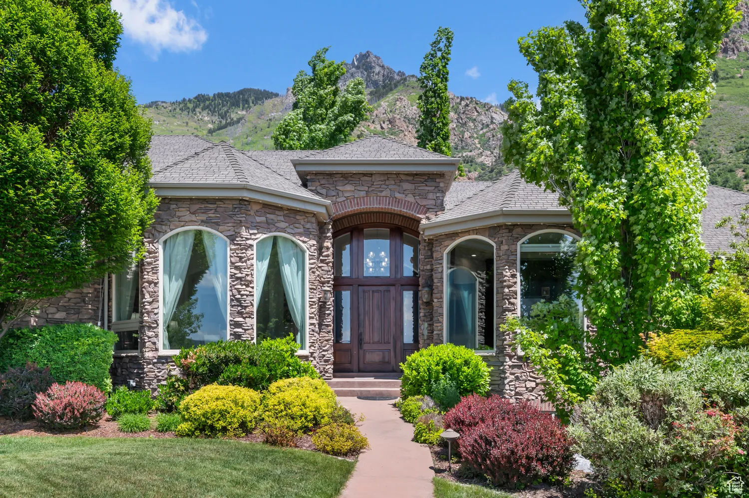 View of front of property with stone siding and a mountain view