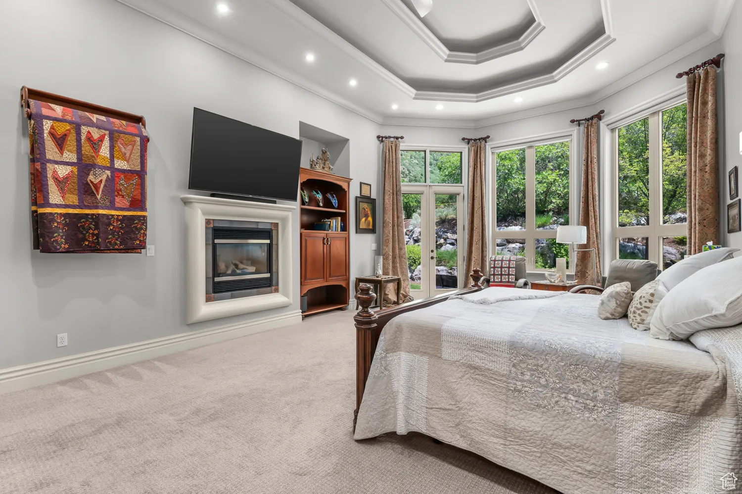 Bedroom with carpet floors, crown molding, multiple windows, a glass covered fireplace, and recessed lighting