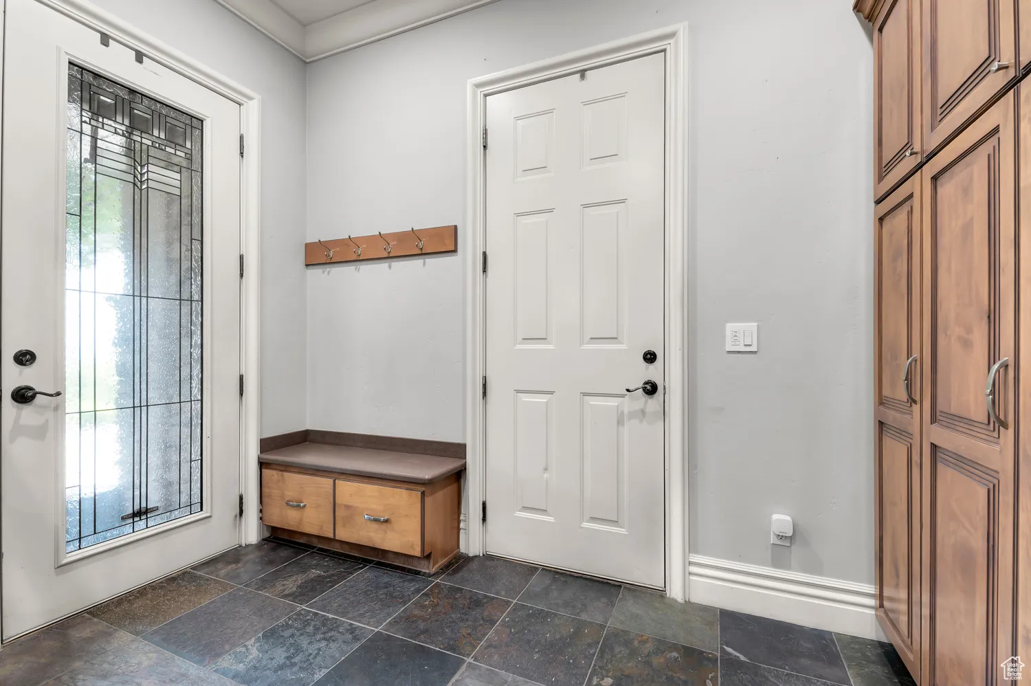 Entrance foyer featuring stone tile floors and baseboards