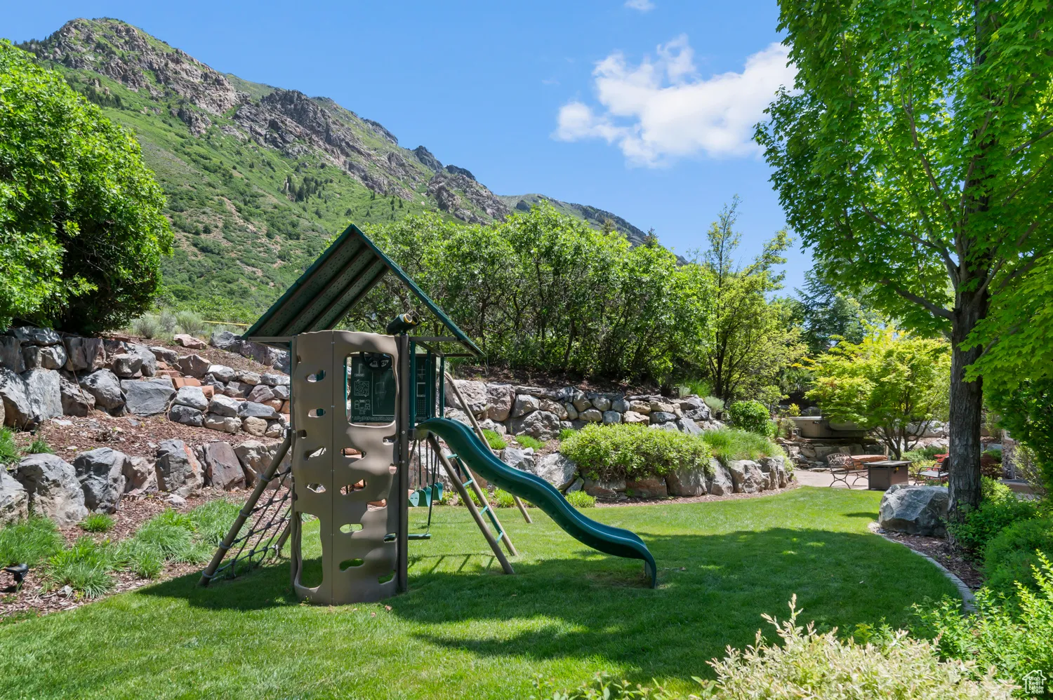 View of play area with a mountain view and a yard