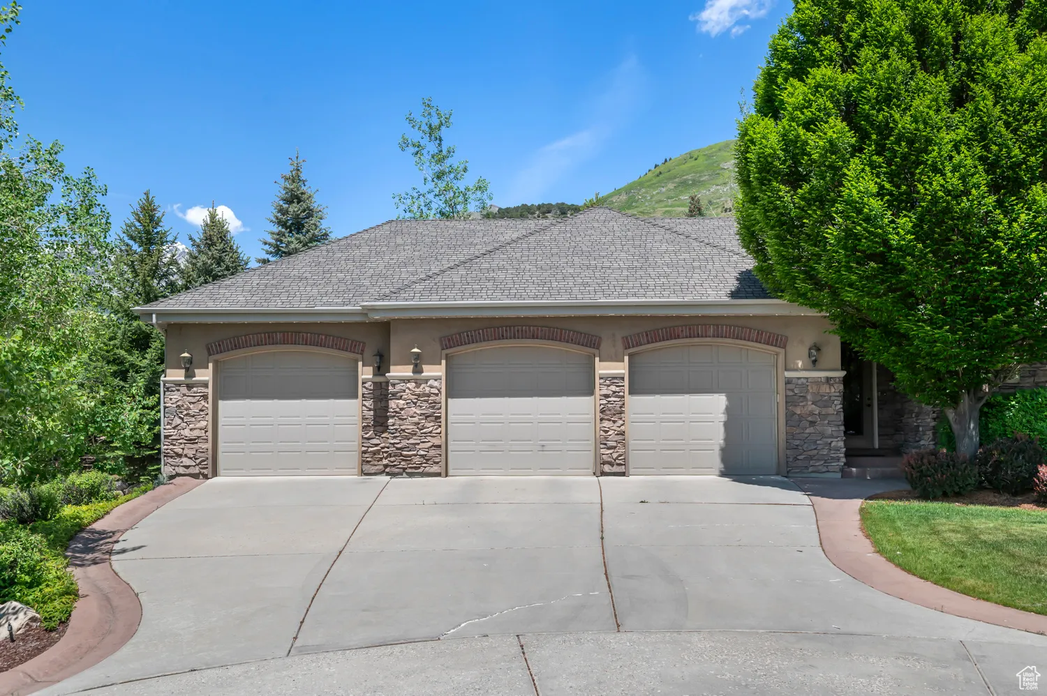 French country style house featuring stone siding, stucco siding, a garage, driveway, and a shingled roof