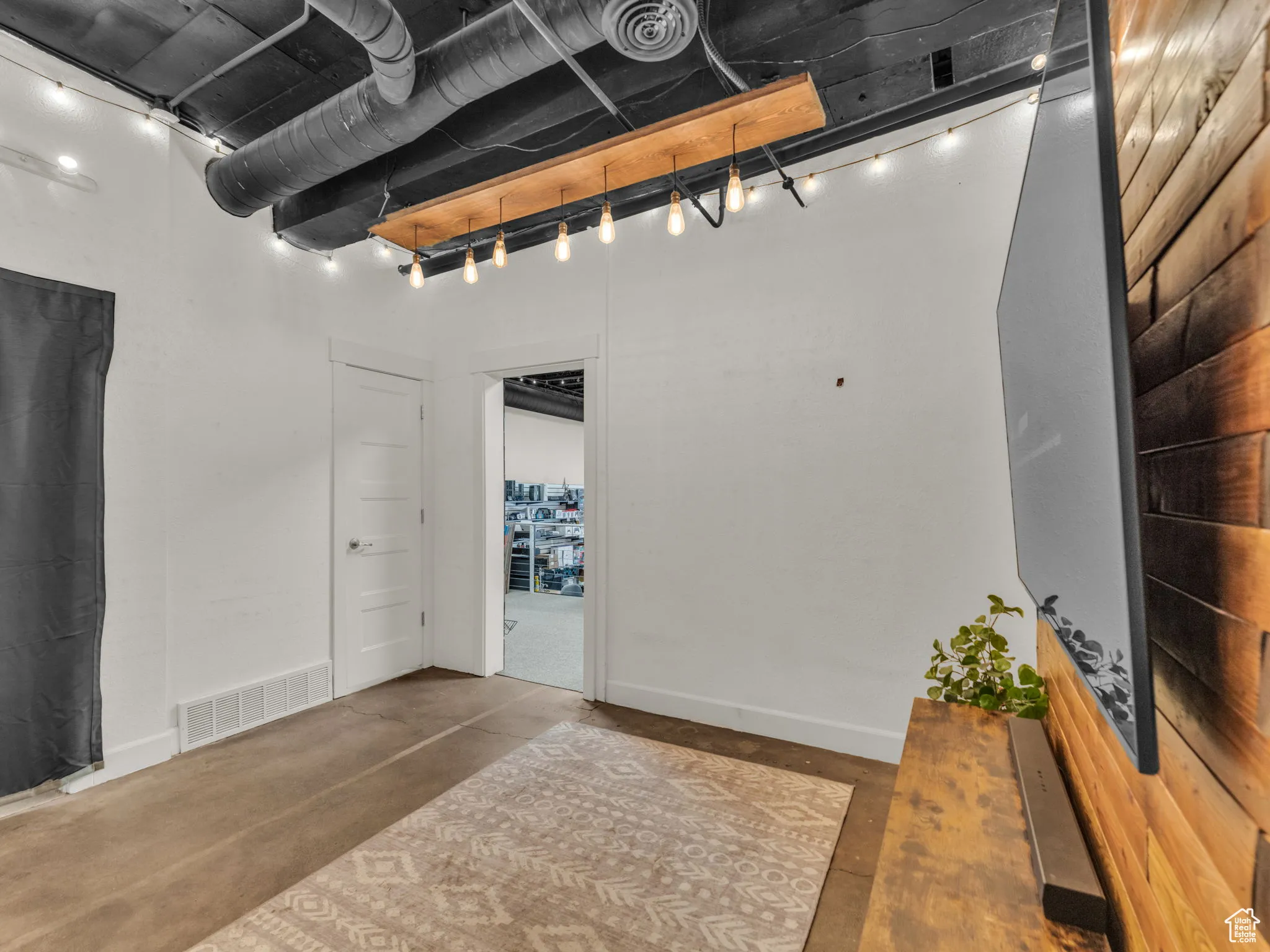 Below grade area featuring rail lighting and baseboards