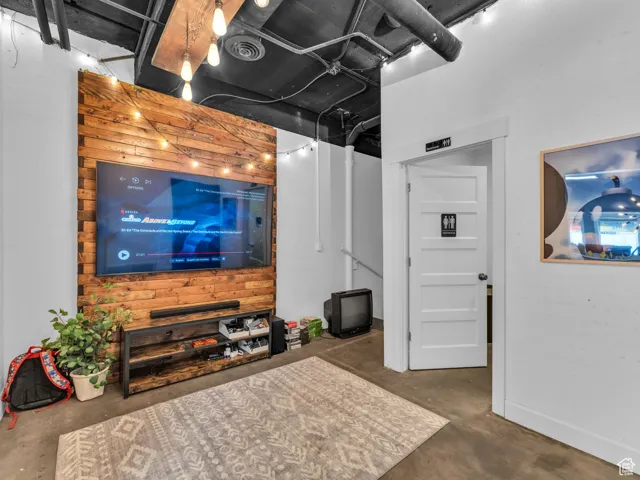 Living area featuring concrete flooring and baseboards