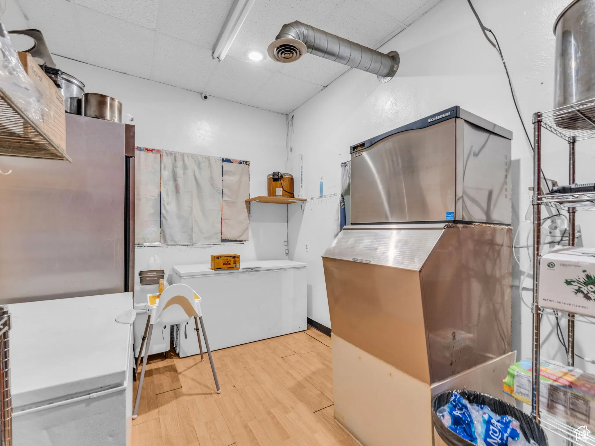 Misc room with a drop ceiling, wood finished floors, and pet washing area