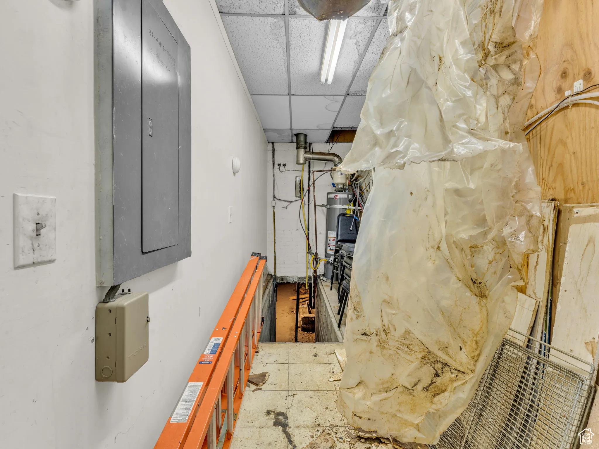 Corridor with electric panel and a drop ceiling
