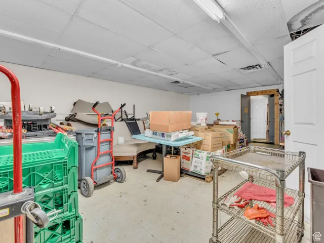 Below grade area with a drop ceiling and tile patterned floors