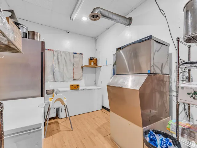 Misc room with a drop ceiling, wood finished floors, and pet washing area