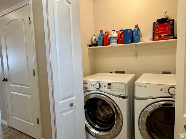 Washroom featuring separate washer and dryer and wood finished floors