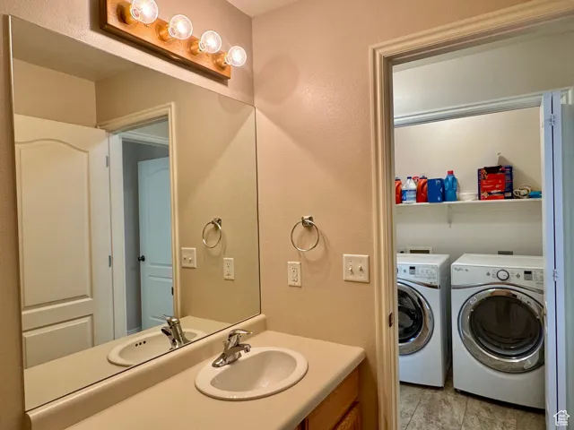 Bathroom featuring separate washer and dryer and vanity