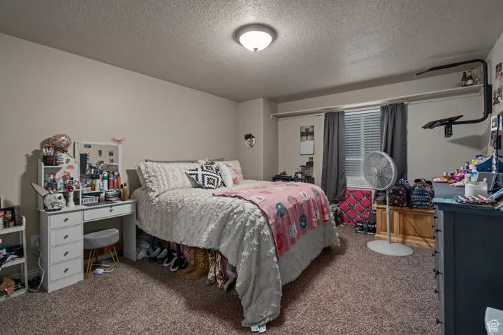 Carpeted bedroom featuring a textured ceiling