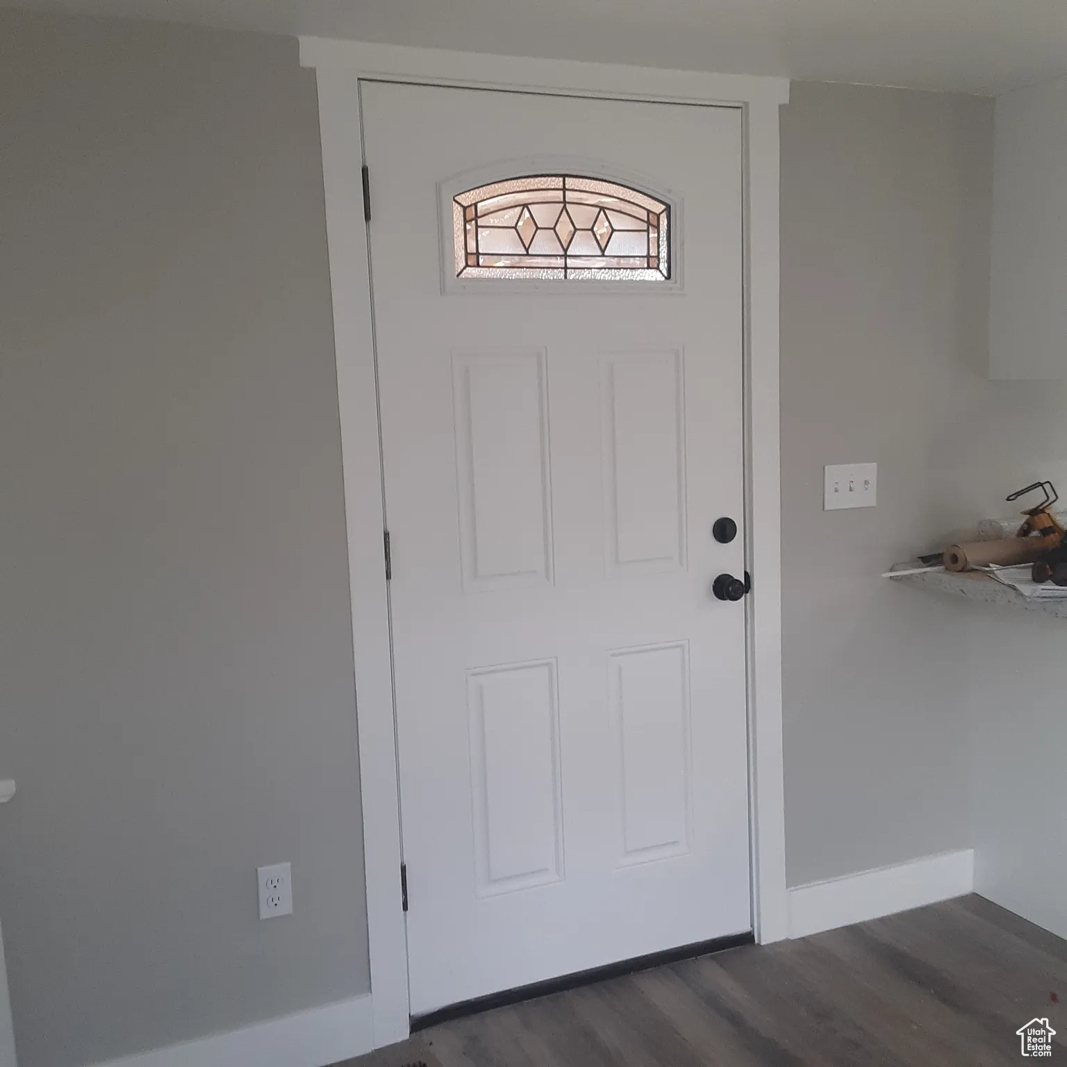 Doorway to outside featuring dark wood finished floors and baseboards