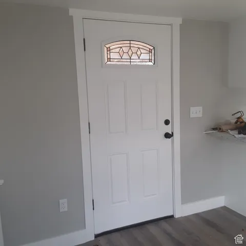 Doorway to outside featuring dark wood finished floors and baseboards