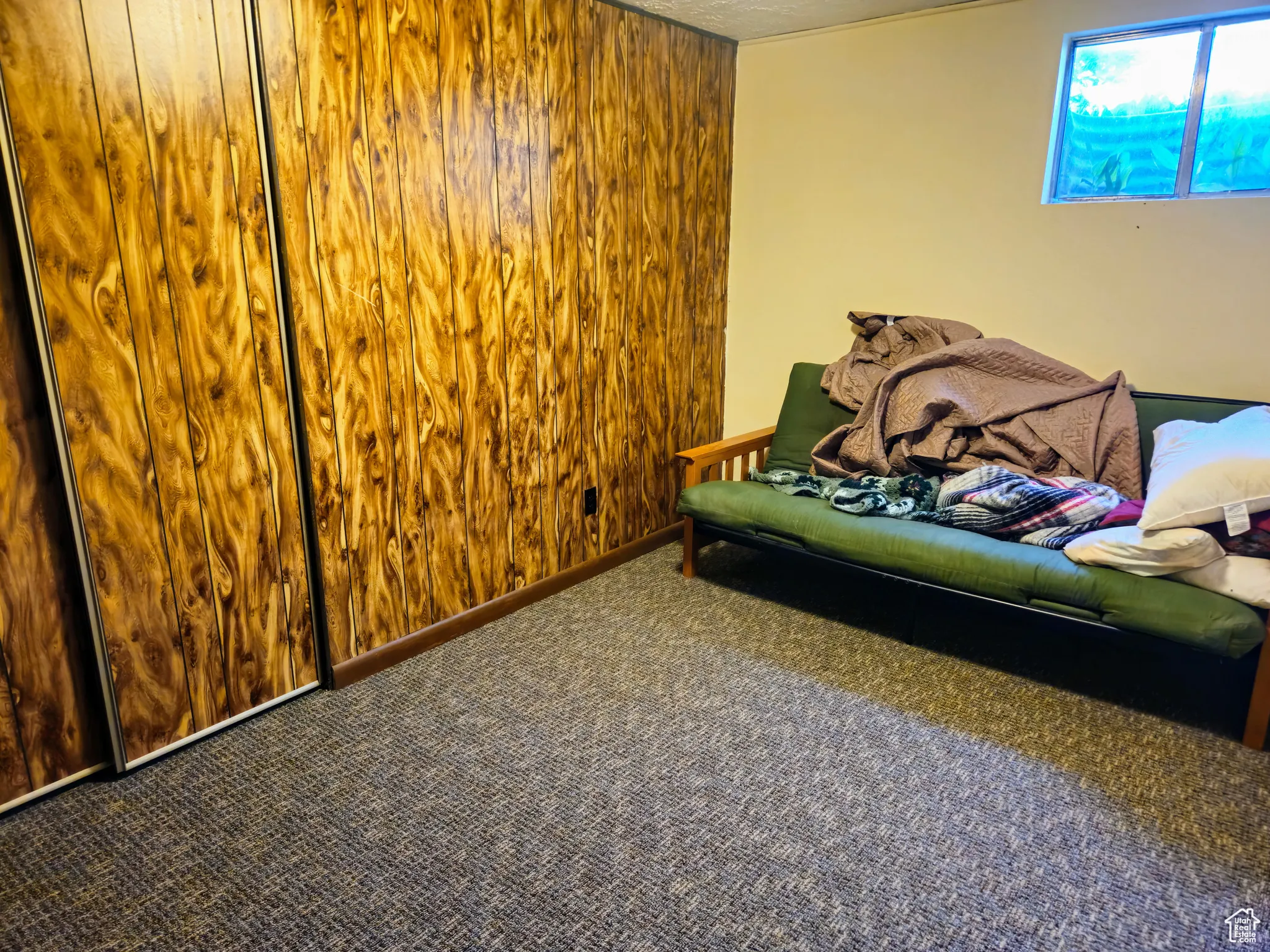 Carpeted bedroom featuring wood walls