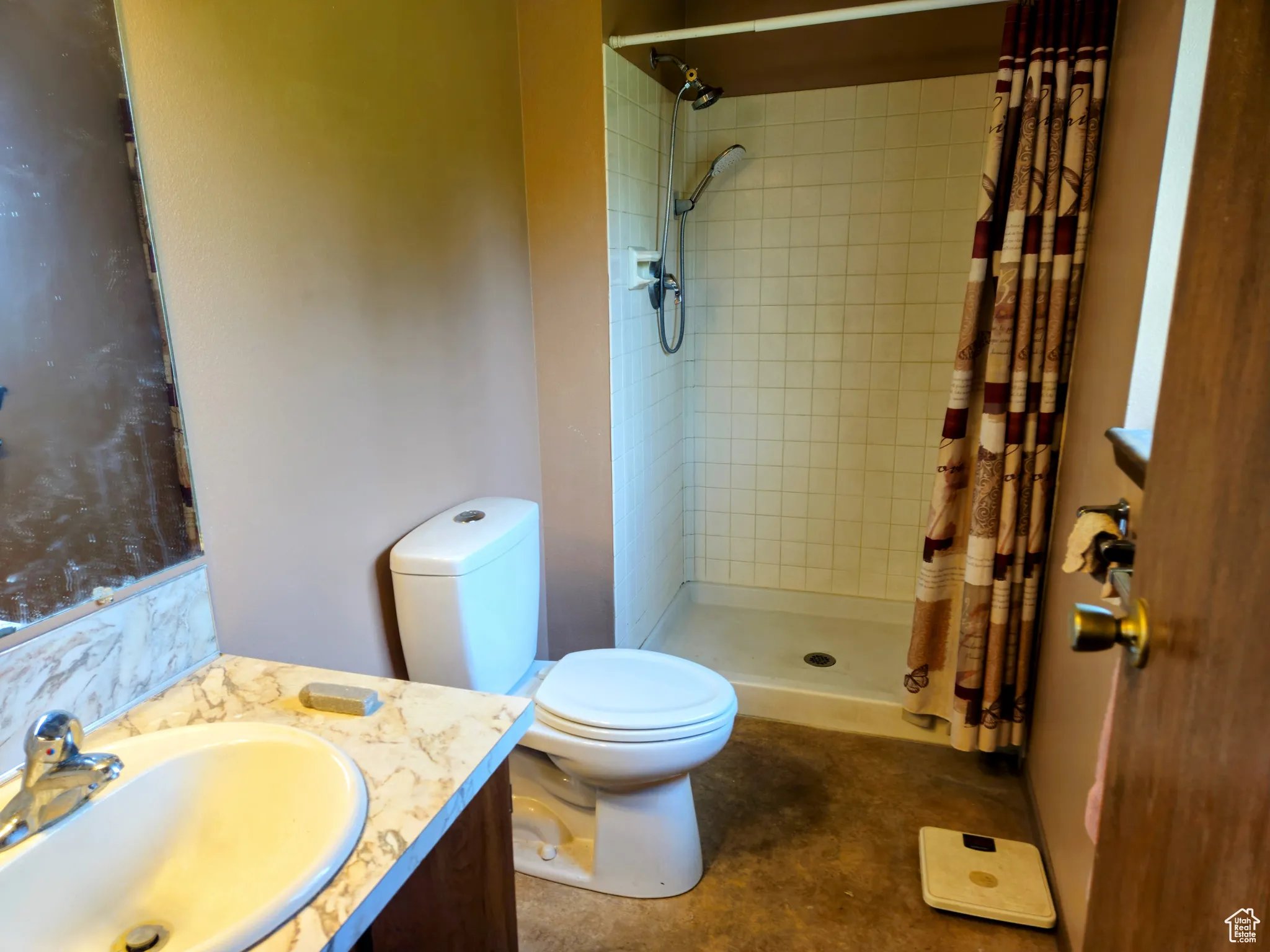 Full bathroom with toilet, a tile shower, and vanity