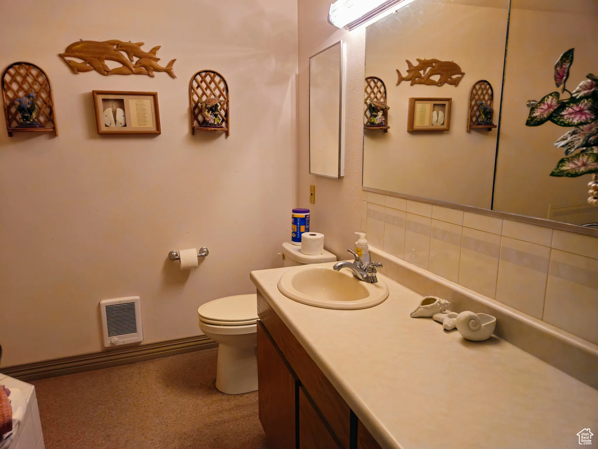 Bathroom featuring heating unit, toilet, and vanity