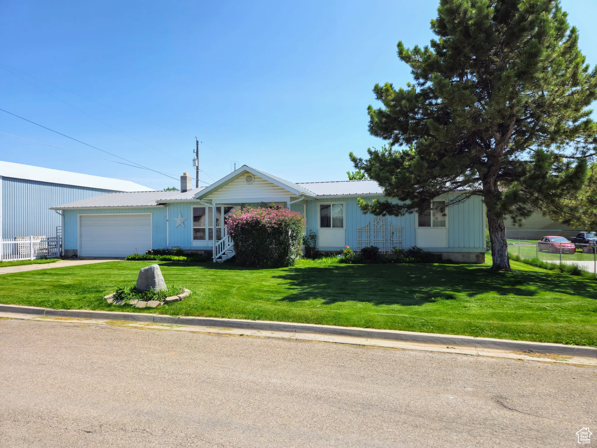 Ranch-style house featuring a garage, driveway, and board and batten siding