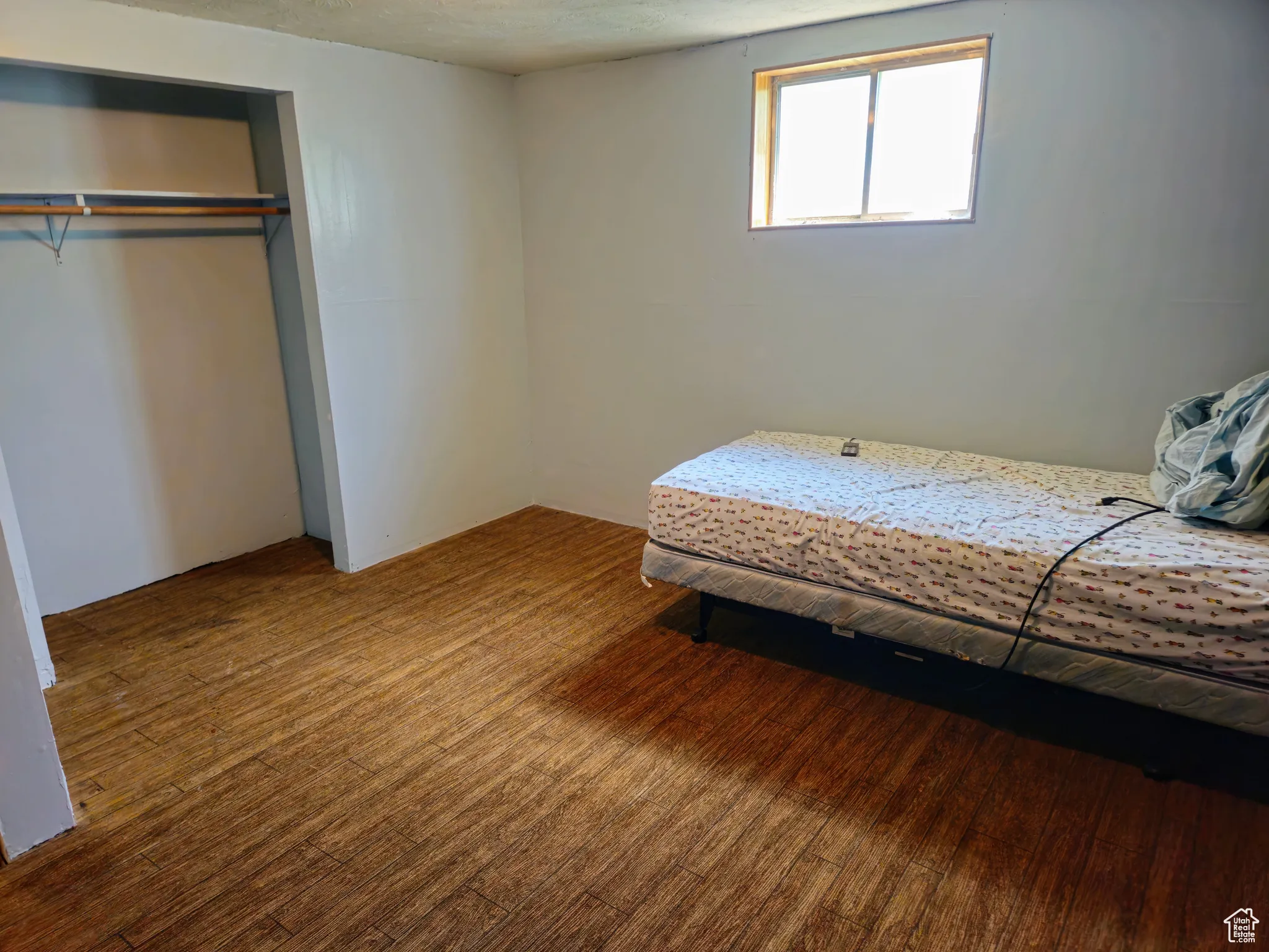 Bedroom with wood finished floors and a closet