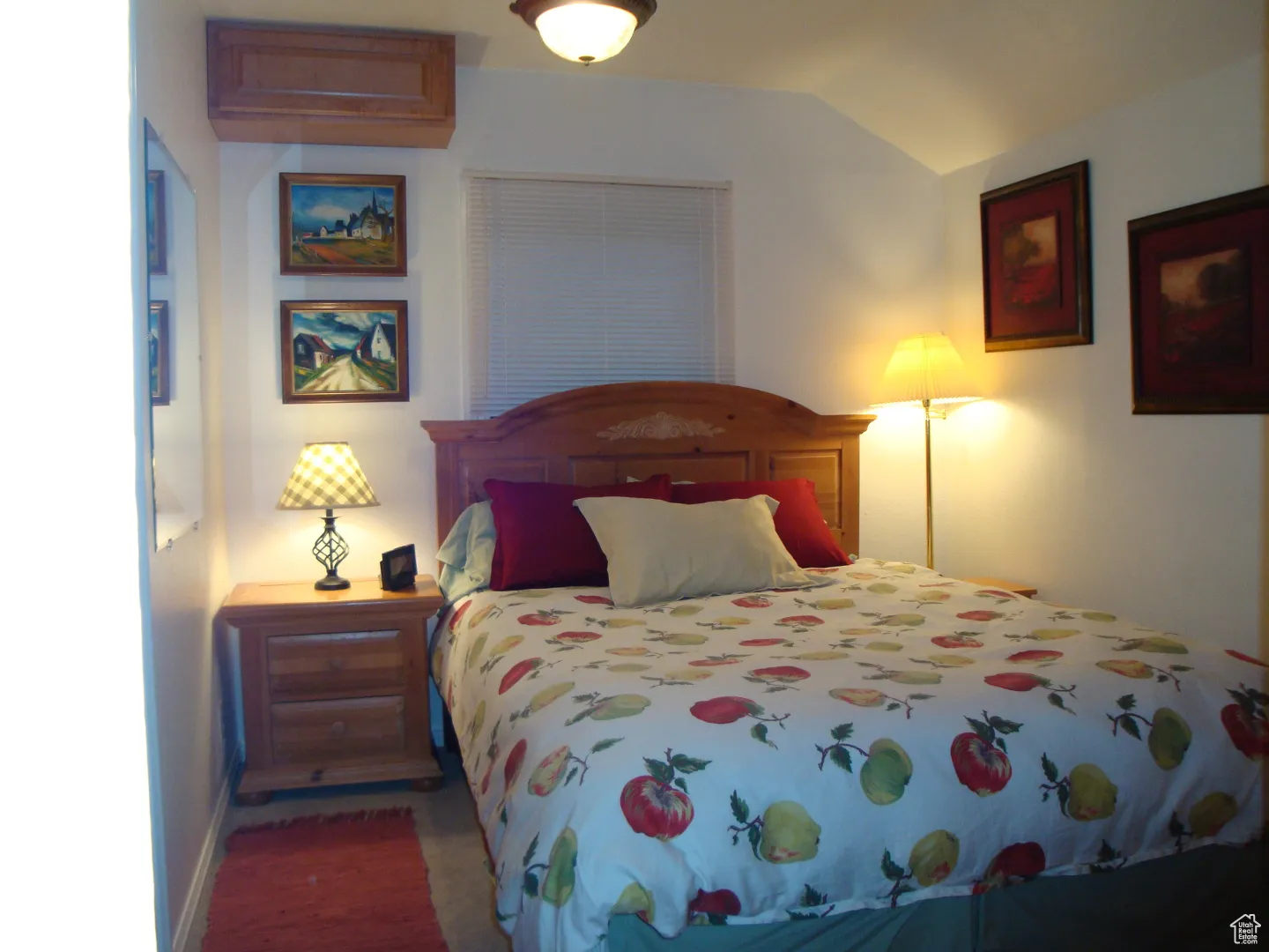 Bedroom featuring vaulted ceiling, baseboards, and wood finished floors