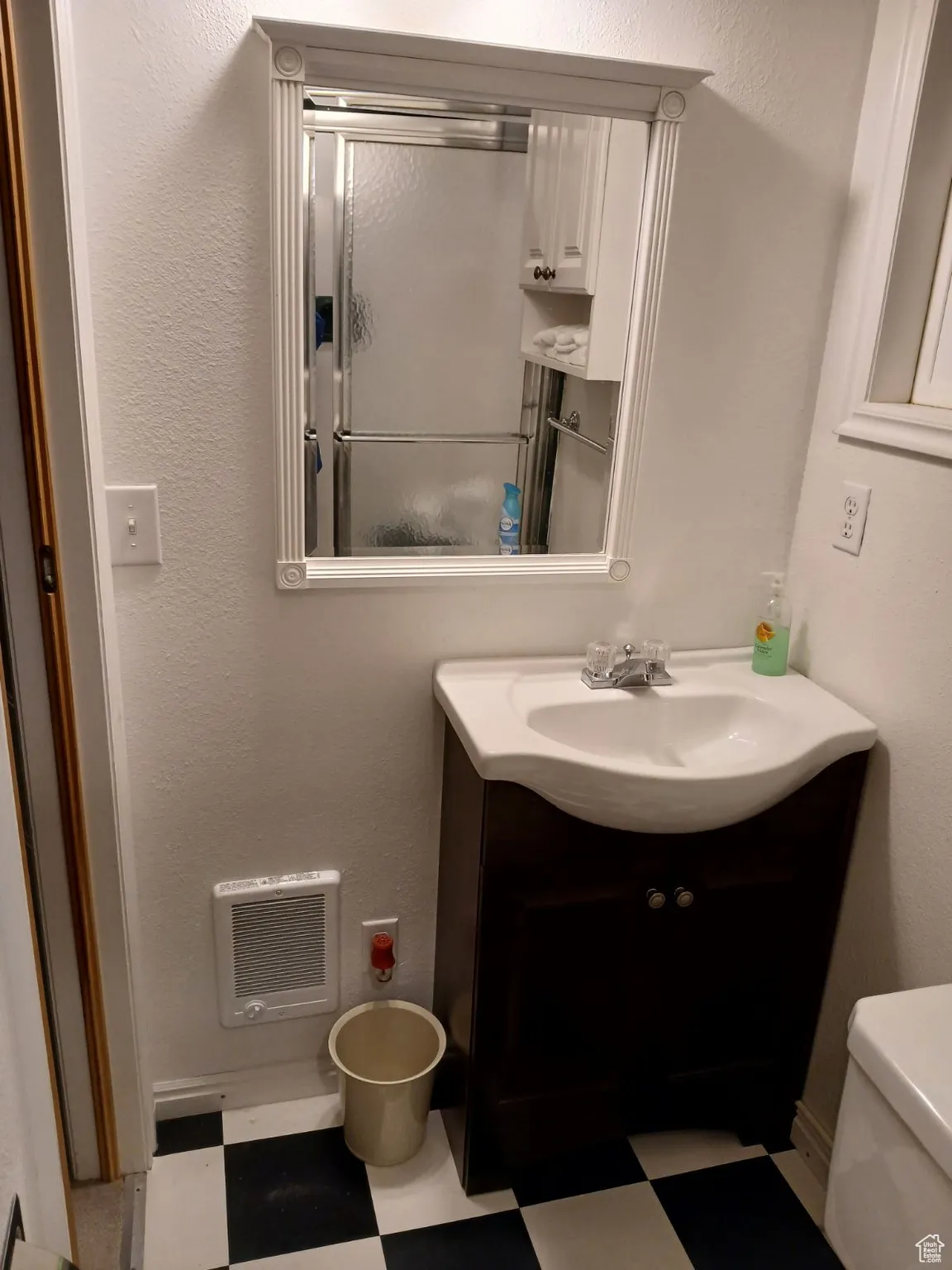 Bathroom with tile patterned floors, toilet, vanity, and heating unit