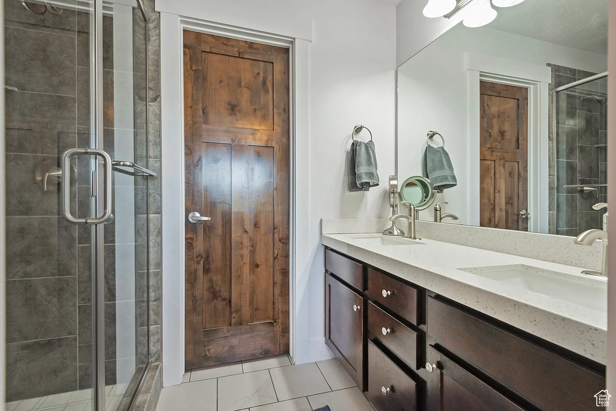 Primary bathroom featuring double vanity and a glass enclosed Shower