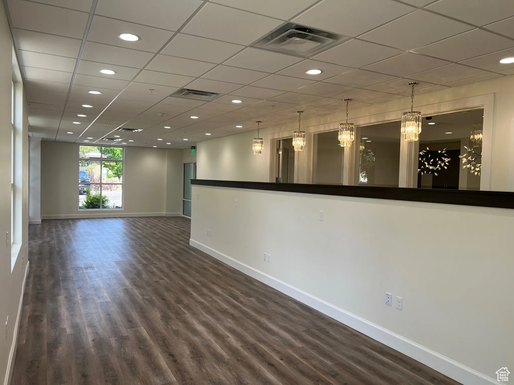 Spare room featuring baseboards, dark wood finished floors, recessed lighting, and a paneled ceiling