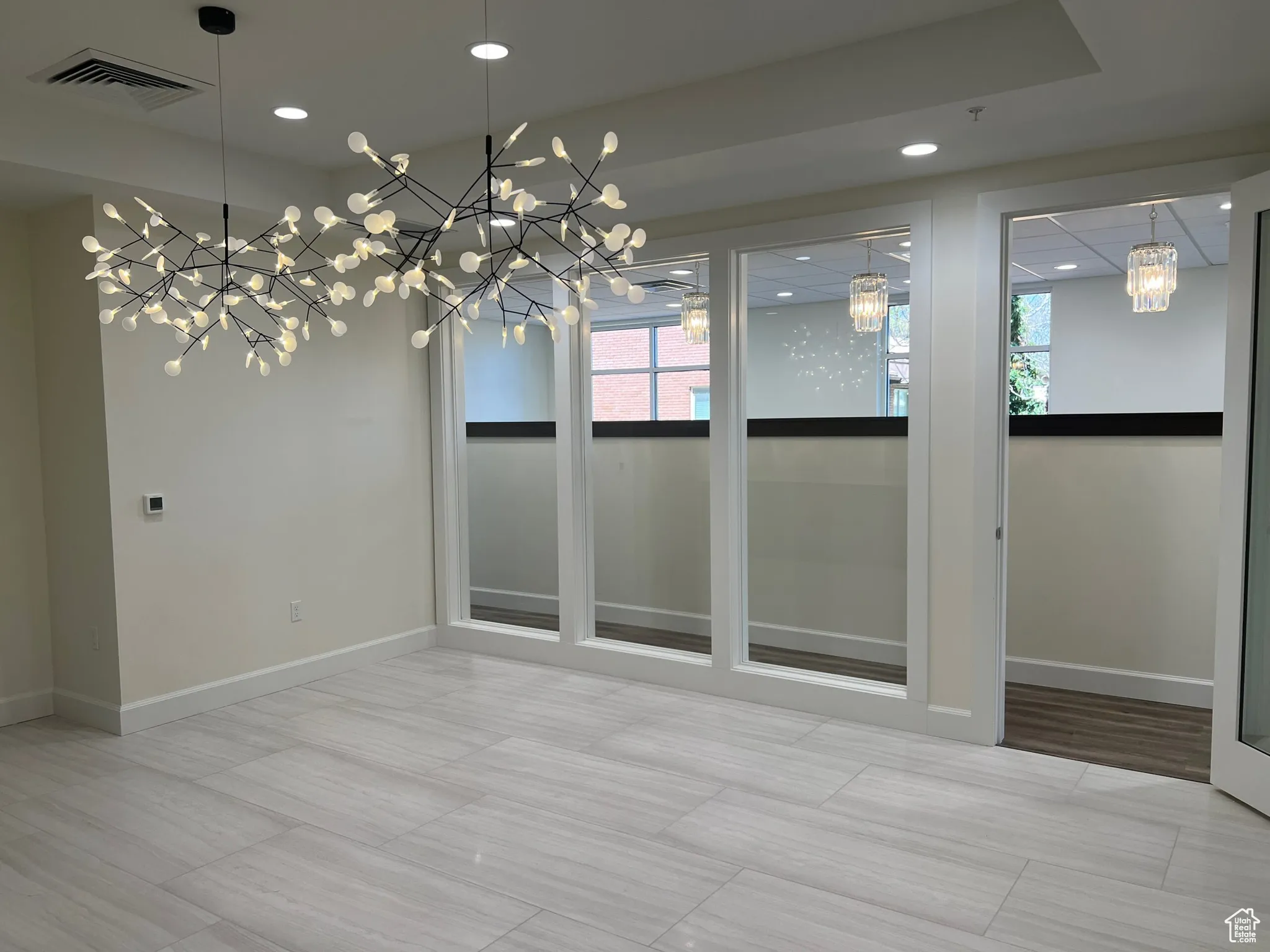 Spare room featuring a chandelier, baseboards, and recessed lighting