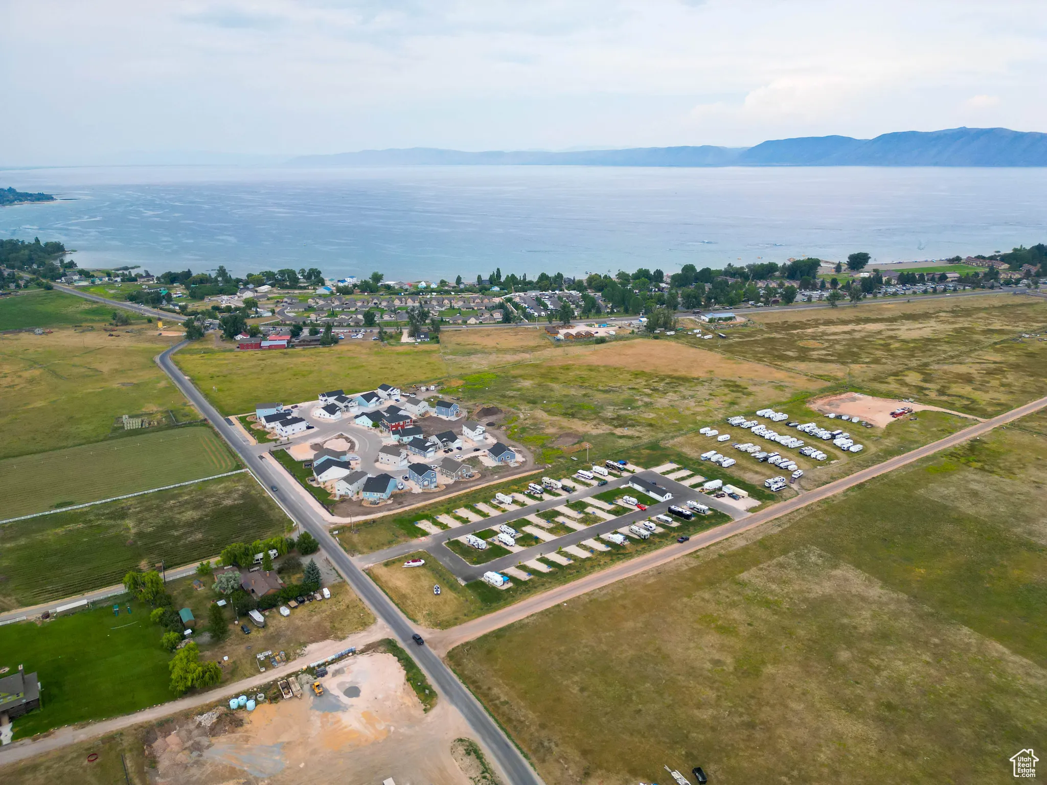 Aerial view of property and surrounding area featuring a water and mountain view
