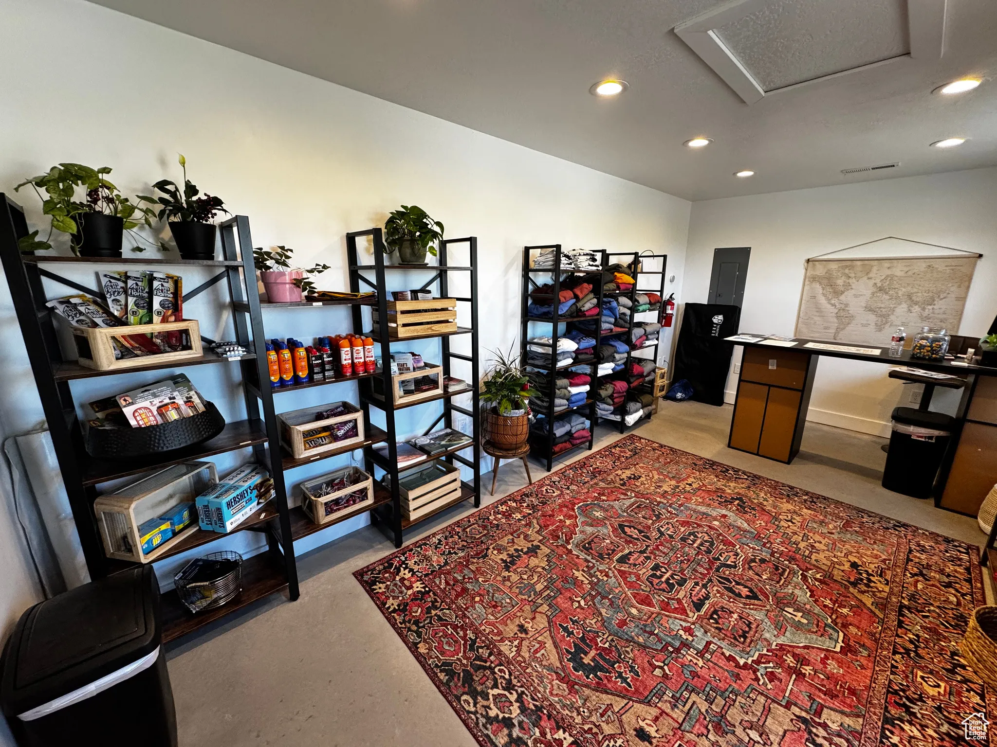 Office space featuring recessed lighting, attic access, concrete flooring, and electric panel