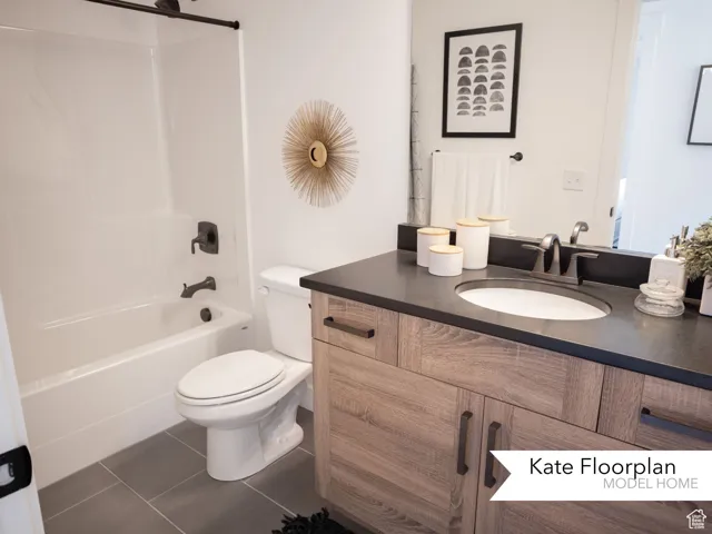 Bathroom with toilet, vanity, tub / shower combination, and tile patterned floors