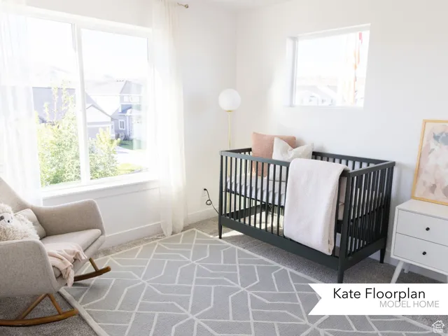 Bedroom featuring carpet flooring, baseboards, and a nursery area