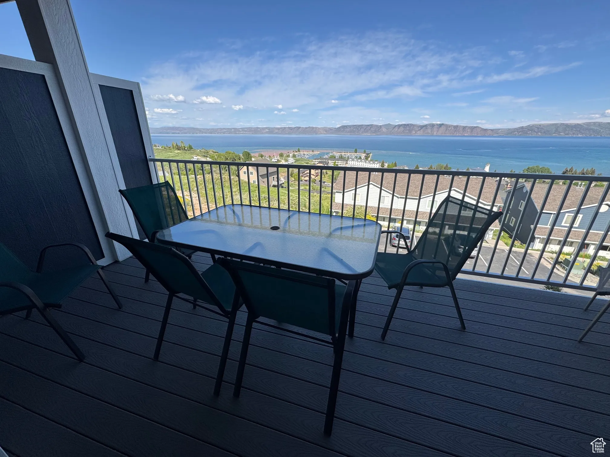 Wooden deck with a water and mountain view and outdoor dining area