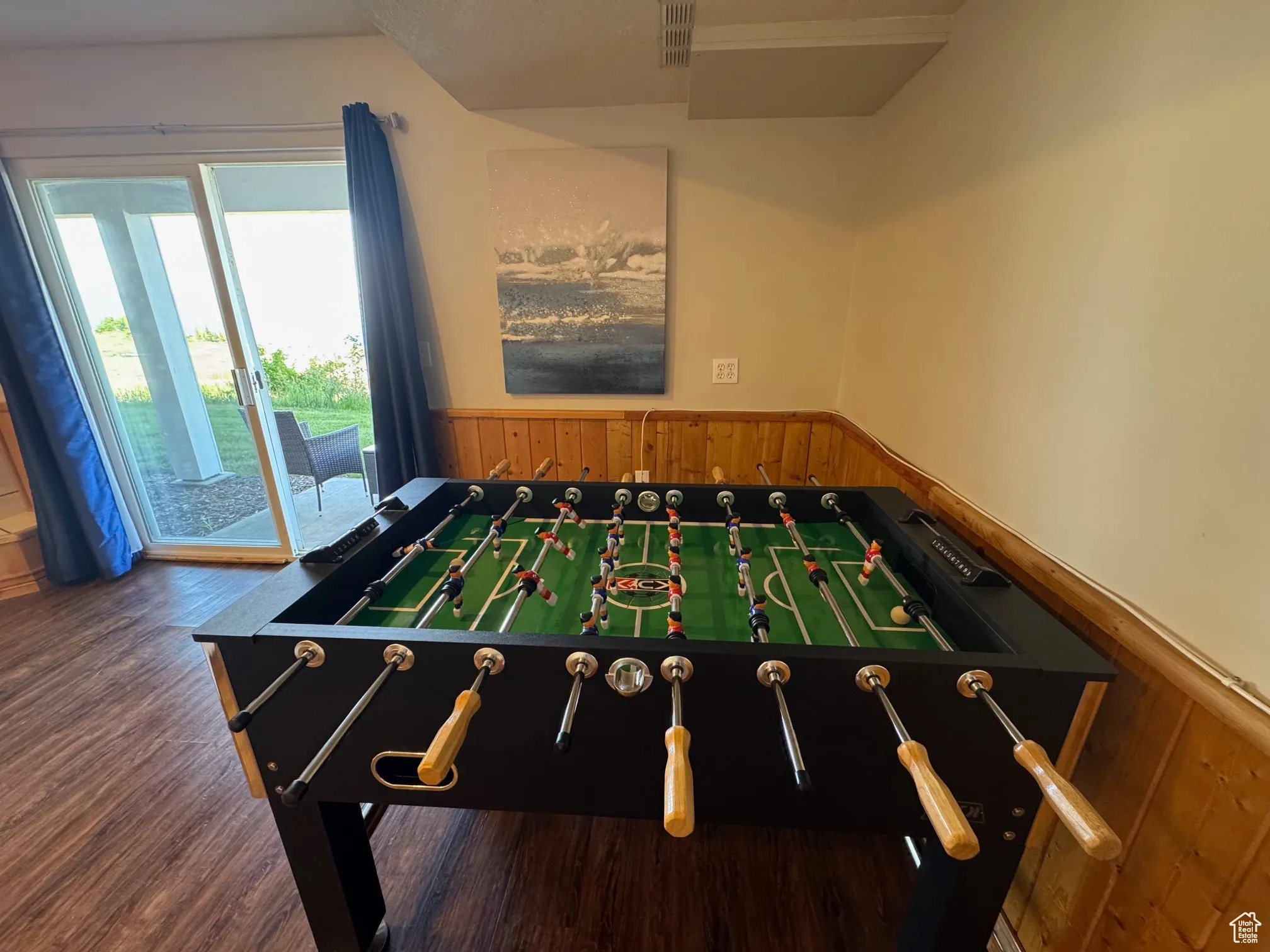 Game room with a wainscoted wall, wood finished floors, and wood walls