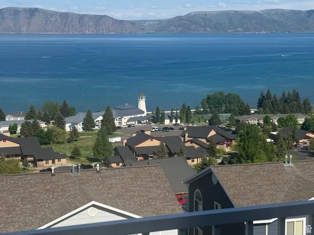 Water view featuring a mountainous background and nearby suburban area