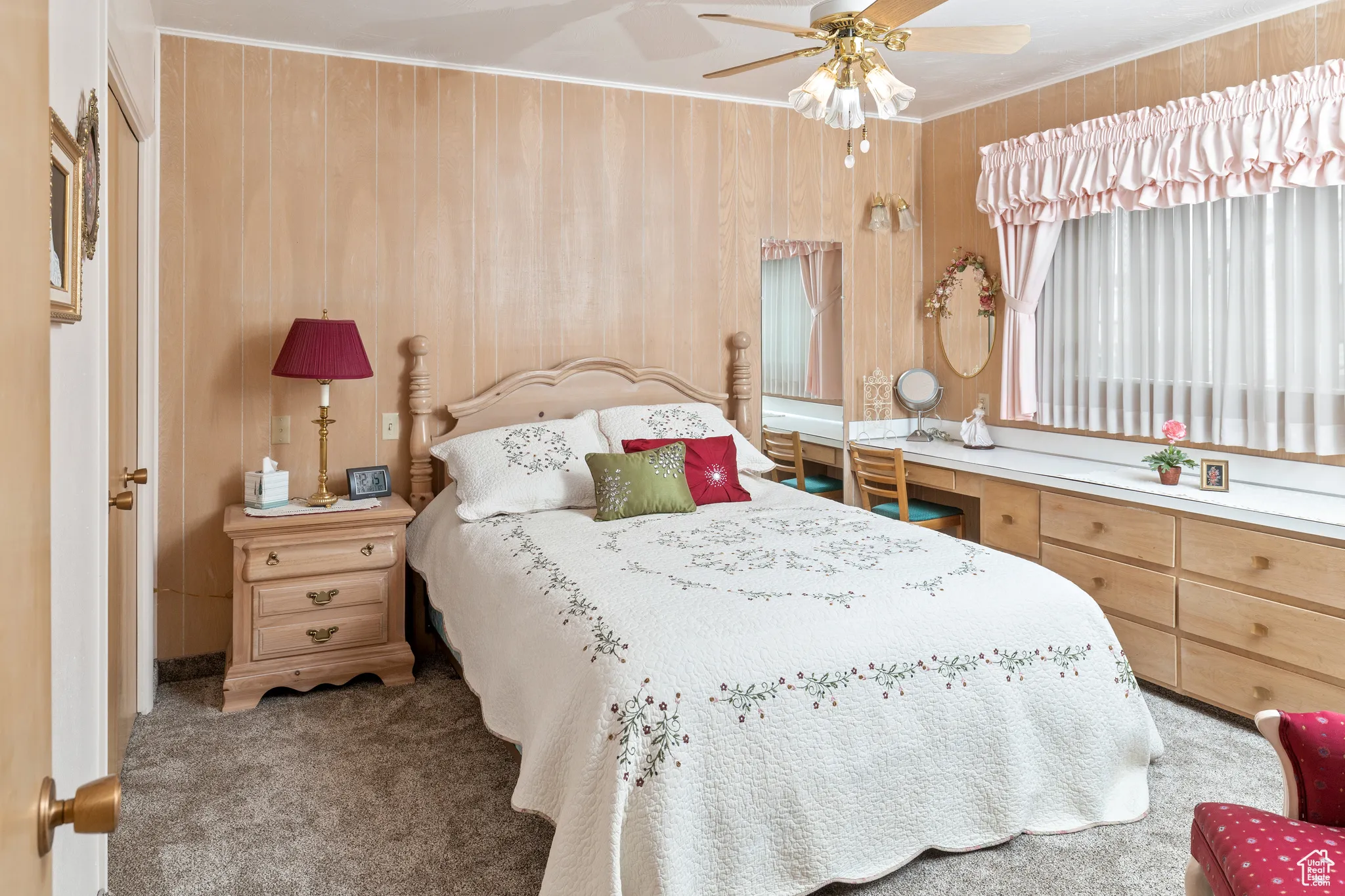 Bedroom featuring carpet flooring, ornamental molding, ceiling fan, and wood walls