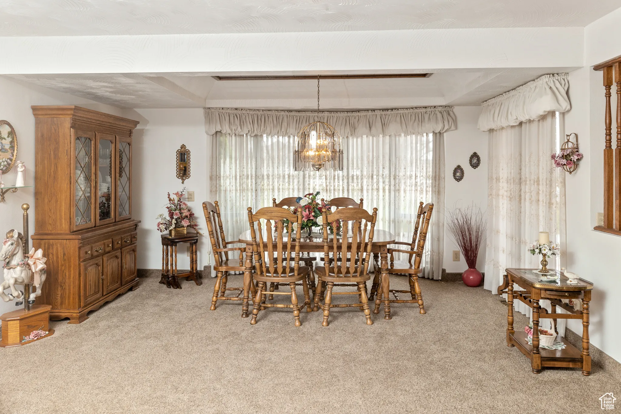 Dining area with a chandelier and light colored carpet