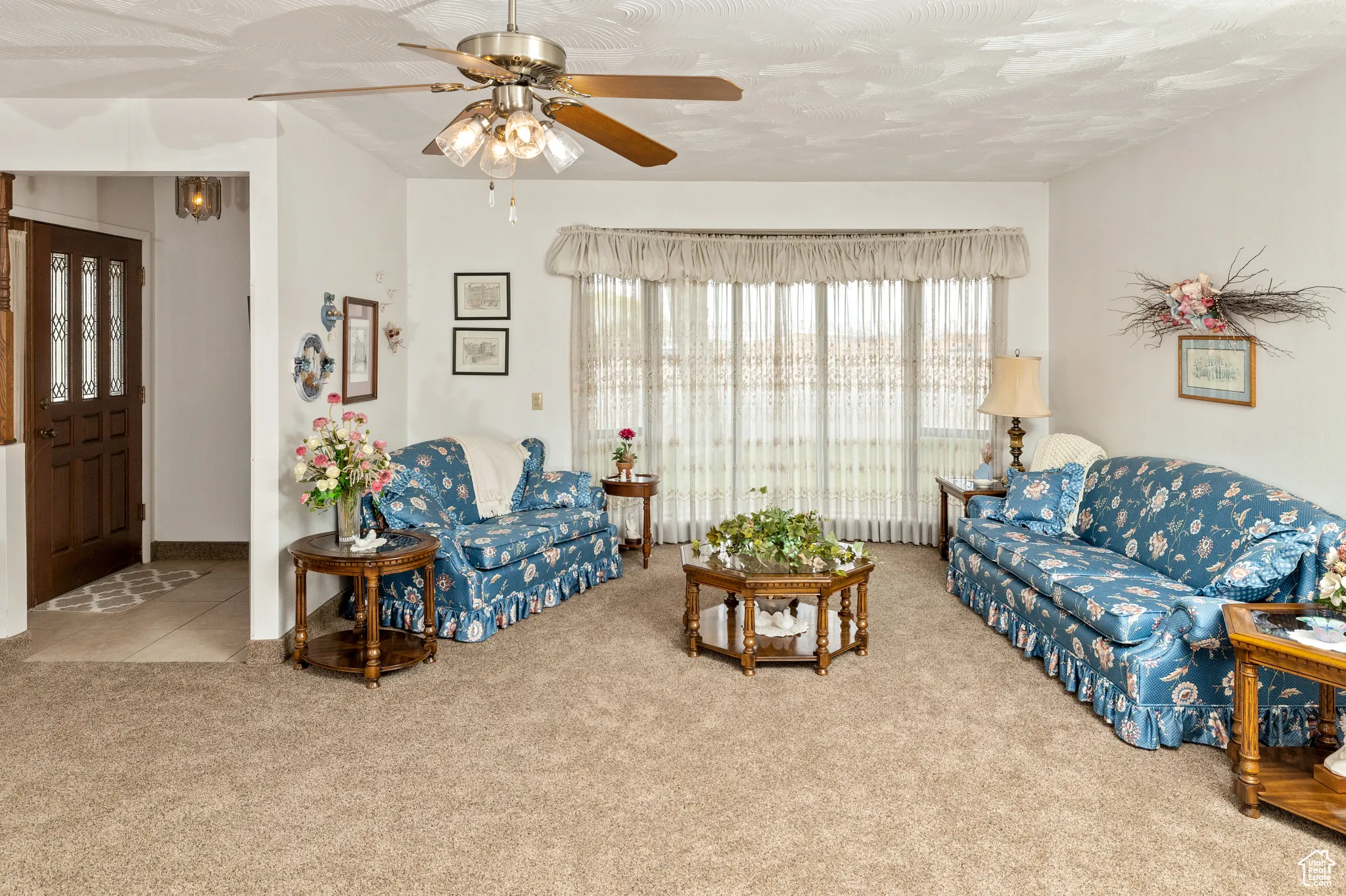 Living room with carpet flooring and a ceiling fan